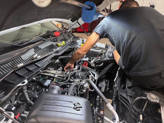 Technician working under the hood at Gearhaven Auto & Diesel